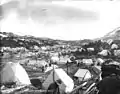 Tent camp with boat building activity and One Mile River in background