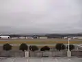 Location of crash of Flight 105 is along runway, perpendicular to the space between the two groups of hangars, slightly to the left of the white parking deck light pole in foreground. Runway 18-36 was extended south after the accident and Village Creek routed through tunnels.