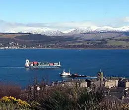 At Gourock a ship heads for the container cranes at Greenock, passing the Caledonian MacBrayne Dunoon ferry. Across the firth MV&nbsp;Kenilworth leaves Kilcreggan for Helensburgh.