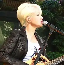 Cyndi Lauper playing a guitar.
