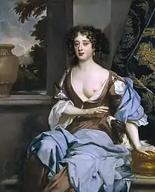 The picture centres on an attractive woman in her late twenties, dressed in long flowing robes suggesting a rural idyll, with one breast exposed towards the viewer. She has dark hair, and a wistful expression.