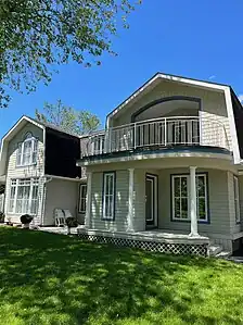 a) Arched, inset upper balcony, b) Front verandah (built, 1982)