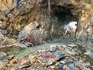 2018 photograph of Needle's Eye Tunnel, near the summit of Rollins Pass. This view shows the northeast portal in the foreground; the southwest portal can be seen in the background. Wire mesh and metal dowels were installed in August 1987 to help reduce additional rock falls and preserve the condition of the tunnel constructed in 1903 (121&nbsp;years ago)&nbsp;(1903).