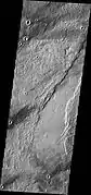 Southern end of Enipeus Vallis is about 10&nbsp;km wide and broadly U-shaped in profile. The western wall of the valley has a straight NE orientation similar to that of fractures in the Noachian plateau materials to the east. This suggests that the valley formed along pre-existing faults. (THEMIS VIS image)