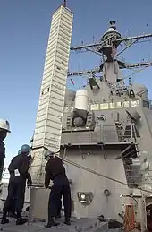 A Tomahawk missile canister being loaded into a VLS aboard the Arleigh Burke-class destroyer USS&nbsp;Curtis Wilbur