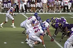 Players crouched on either side of a football